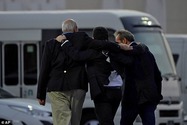 From left to right, Morad Tahbaz, Siamak Namazi and Emad Sharghi walk arm in arm away from a Qatar Airways flight that took them from Tehran to Doha, Qatar, on Monday, September 18, 2023.