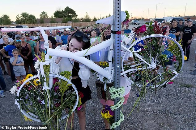 Taylor Probst, left, and Crystal Probst, right, daughter and wife of Andreas Probst, sign a memorial for their father near the site of his death