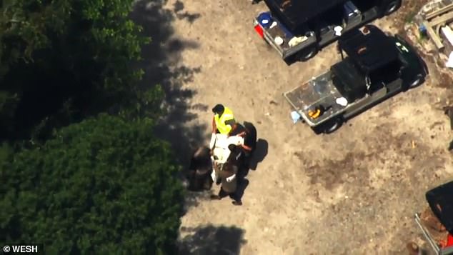 The mysterious tarp was carried to a wooded area across from a dirt parking lot