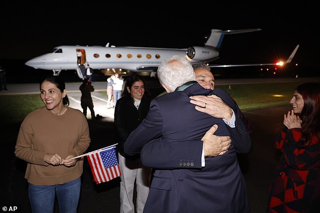 Family members hug the released Americans at the airport Tuesday morning.  They arrived by private jet from Doha