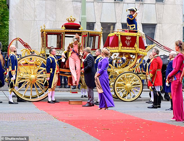 Fanfare: Queen Máxima carefully steps out of the carriage and stands with her husband and daughters, Crown Princesses Amalia and Alexia (far right)