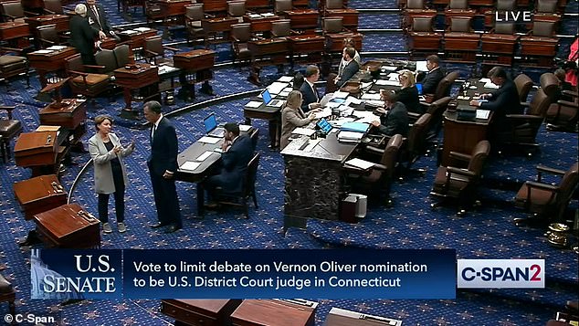 Democratic Sen. Amy Klobuchar of Minnesota took advantage of the new dress code to wear black pants, running shoes and a casual jacket;  she speaks to Senator Mitt Romney on the Senate floor Monday evening