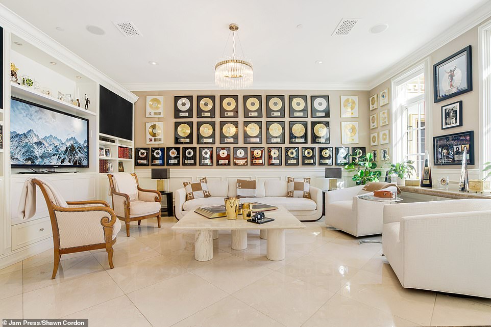 One of the living rooms is pictured above.  It features sleek, glossy floor tiles, neutral white and light brown accents, and Paul's gold and silver plaques on the wall.