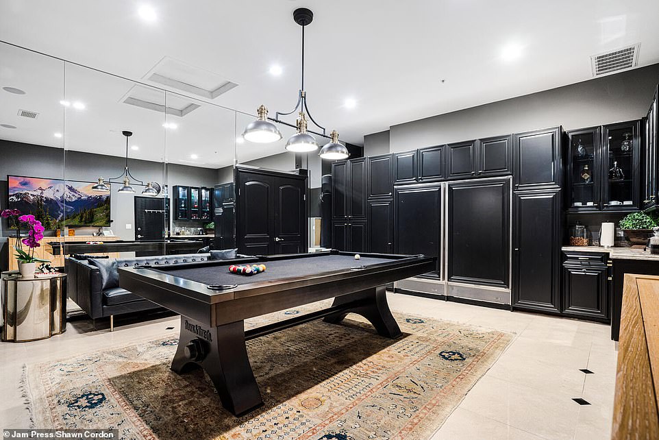 The pool room centrally located off another kitchen allows guests easy access to food and drinks while playing.