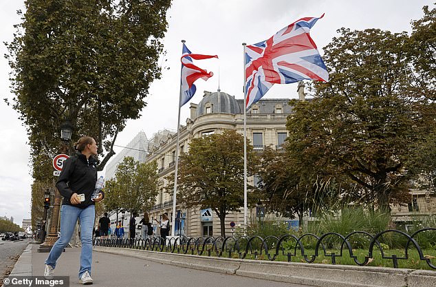 A woman looks at the British and French flags on the Avenue des Champs-Elysées on the eve of the visit of the King and Queen of England on September 19, 2023.