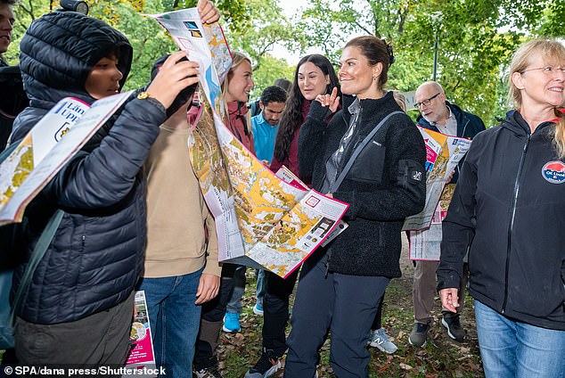 Princess Victoria appeared to look at a large map before going on a hike with a group of people