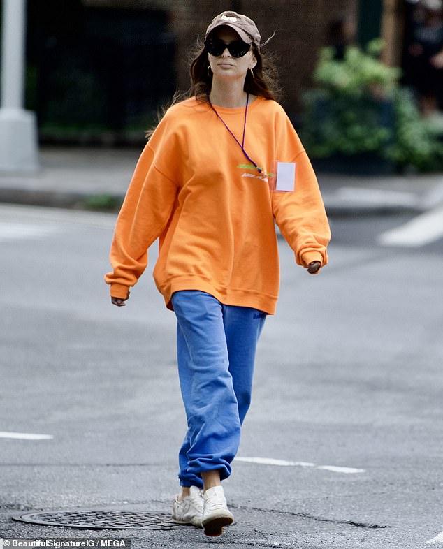 Standing out: The model opted for a much more vibrant clothing ensemble while stepping out on Monday, during which she wore a bright orange crew-neck sweater paired with bright blue sweatpants.