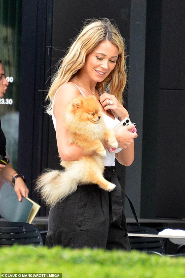 Adorable!  Diletta was pictured cuddling up with her little dog before sitting down to enjoy a lovely meal in Milan.