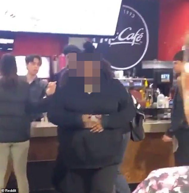 One of the four girls walks away from the counter as the scene turns into a full-scale brawl.