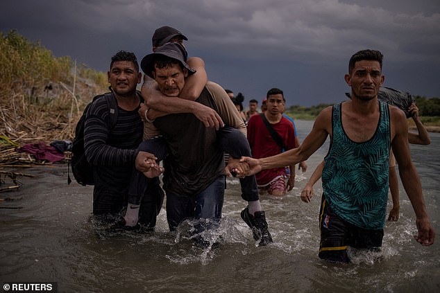 Migrants from Venezuela wade through the Rio Grande to arrive at Eagle Pass on September 15