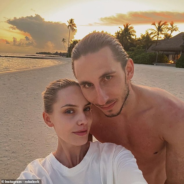 The pair pose for a selfie together during a holiday as they enjoy each other on a beach