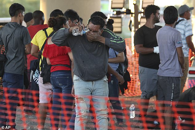 Migrants wait under the International Bridge II in Eagle Pass, Texas, on Wednesday after illegally crossing into the U.S. on the Rio Grande River