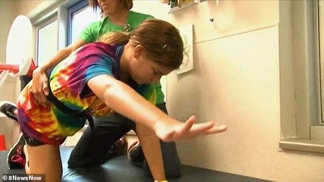 She is pictured above undergoing rehabilitation to regain her skills.  A year after the infection, she was able to swim again