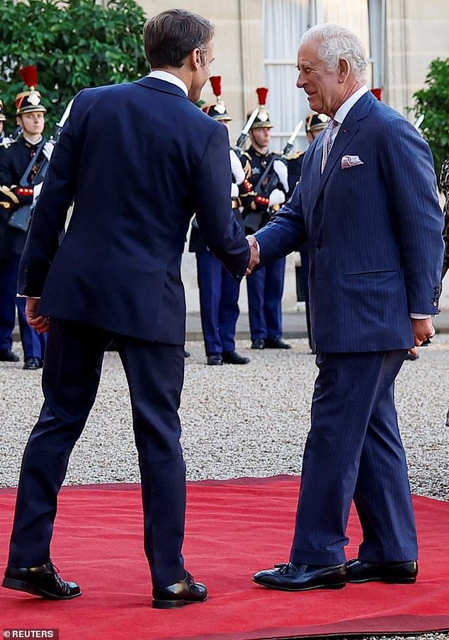 Meanwhile, the two men – Emmanuel Macron (pictured, left) and King Charles (pictured, right) shake hands.