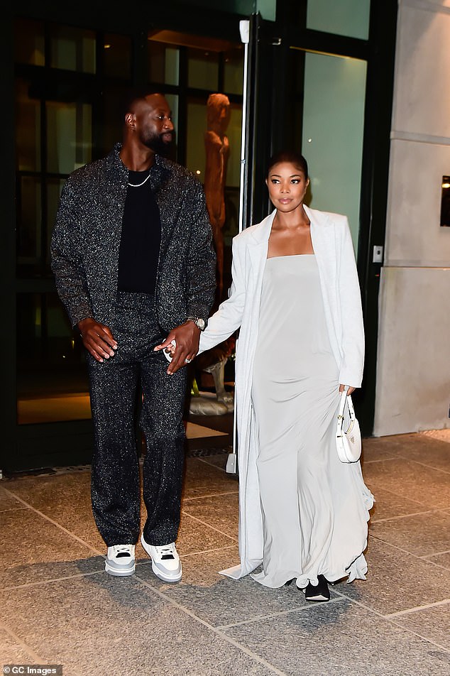 Night out: Wade also wore a diamond-studded earring and diamond necklace, while completing his look with white and gray sneakers