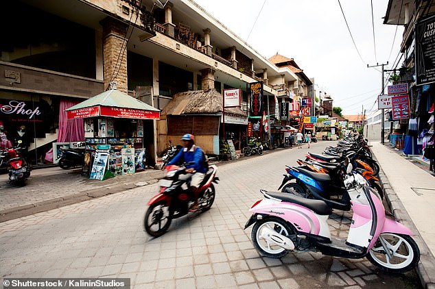 Motorbikes are so common in Bali that criminals can hide and leave it until the last second before diving.  Pictured: A stock photo of a man riding a scooter in Bali