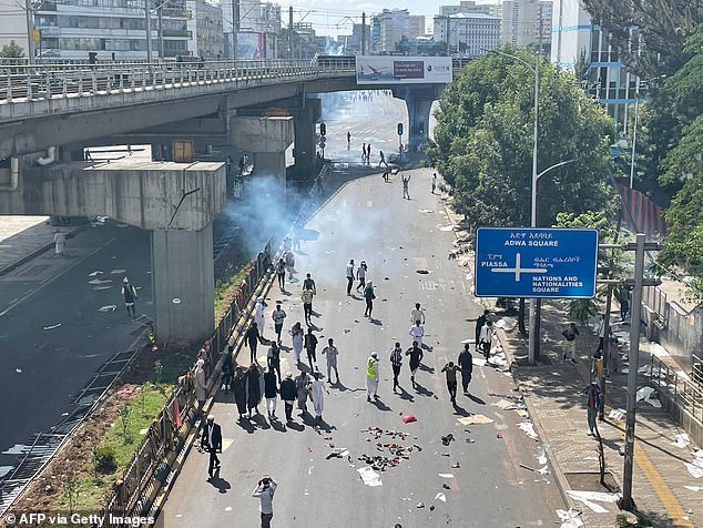 Protesters take cover as security forces fire tear gas at them during a protest in Addis Ababa in May 2022