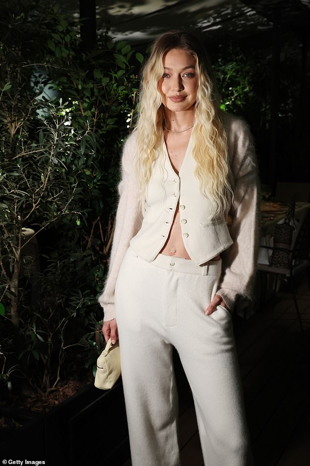 Woman in White: Gigi stood out in white, befitting her status as guest of honor.  She accentuated her flat midriff while wearing a cream-colored cardigan that was only partially buttoned at the top