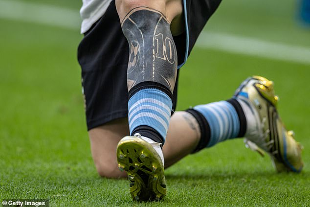 The heavily inked football star's shin is completely covered in black ink with the number 10, the FC Barcelona crest, a football and the Argentine FA badge