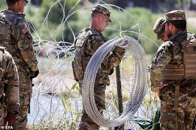 Members of the Texas National Guard repaired the fence Thursday, but the migrants crawled under it