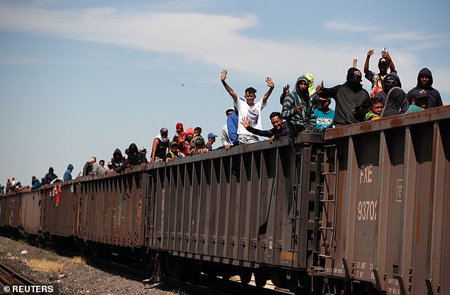 Migrants wave from the train at Paredon, in the southern Mexican state of Chiapas