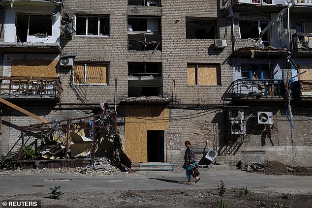 A woman walks past a residential building damaged by a Russian military attack, amid the Russian attack on Ukraine, in Pokrovsk, Donetsk region, Ukraine, September 21, 2023