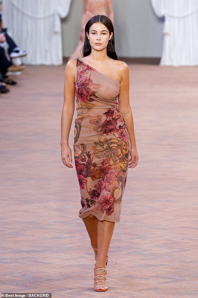 Working: The 19-year-old model strutted her stuff down the catwalk and looked sensational in a one-shoulder floral dress