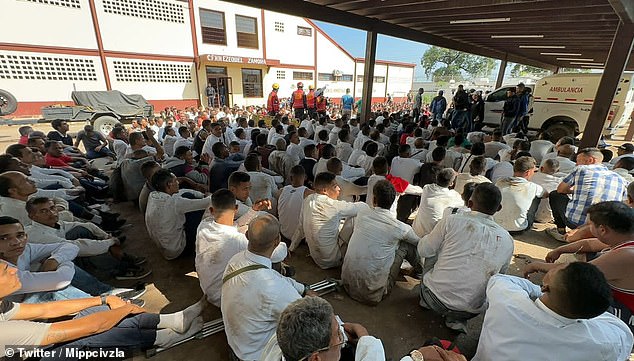 Prisoners in Tocorón's prison center sit next to each other after 11,000 police and soldiers stormed the prison and took back control on Wednesday