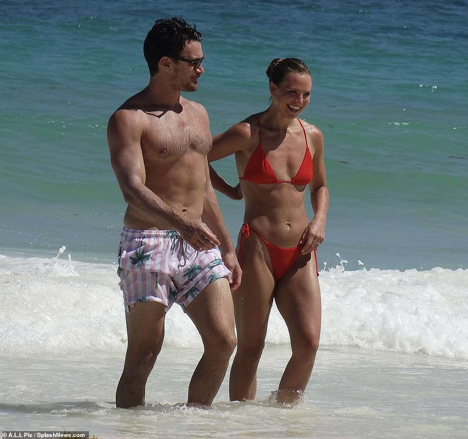 Surfing: The newly engaged couple enjoy a getaway to Tulum, Mexico, where they were spotted frolicking in the surf