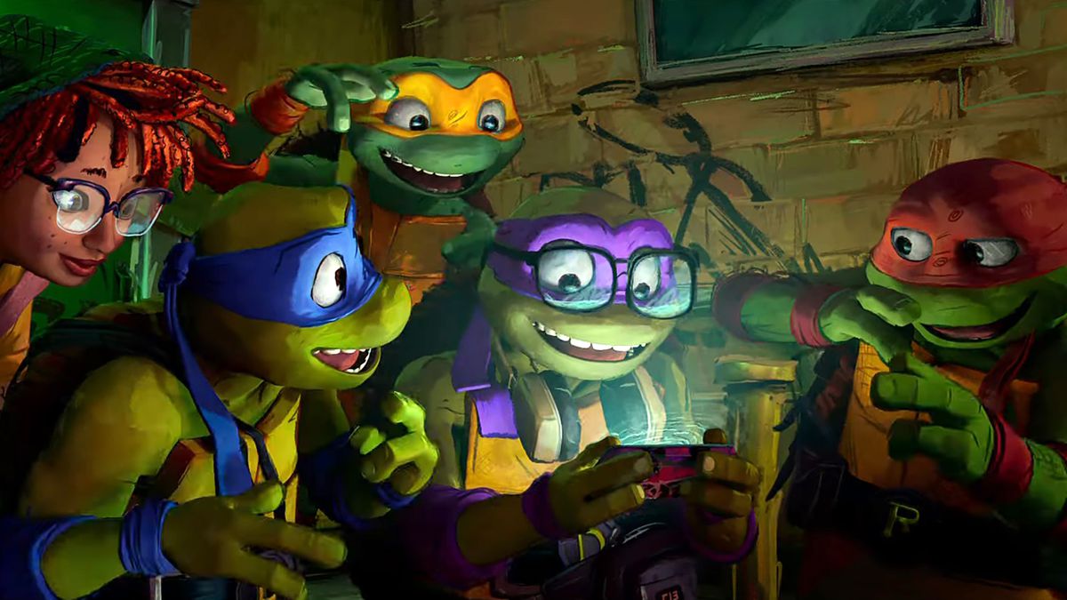 April O'Neil, Leonardo, Donatello, Raphael and Michelangelo laugh while looking at a cell phone in a still from Teenage Mutant Ninja Turtles: Mutant Mayhem