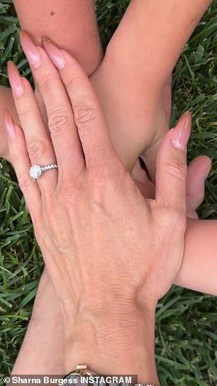 Flashy ring: His children's hands then rested gently on his, while Sharna finally placed her hand on top to show off a striking diamond engagement ring