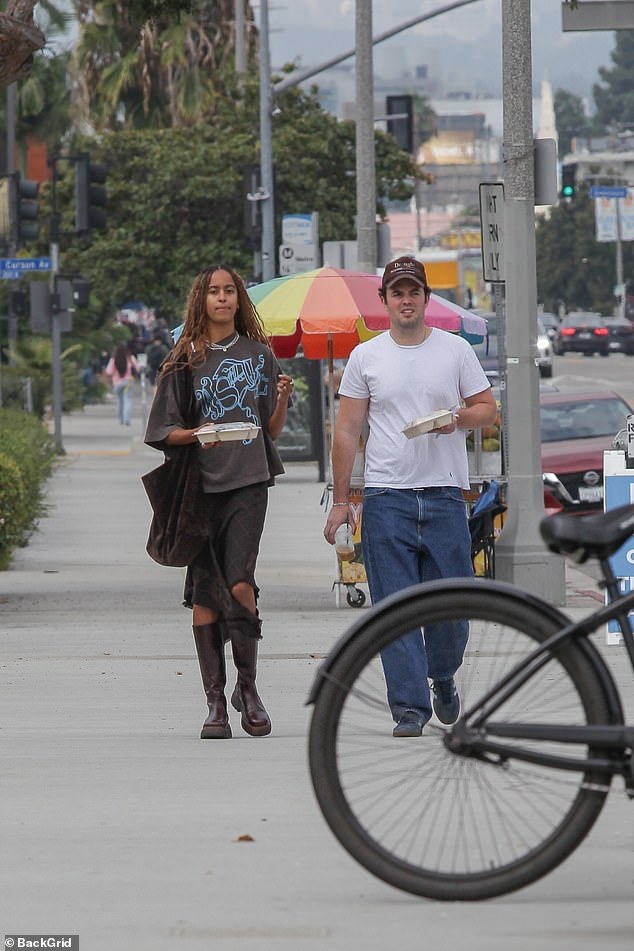 The pair were seen walking outside with containers of their leftovers in their hands