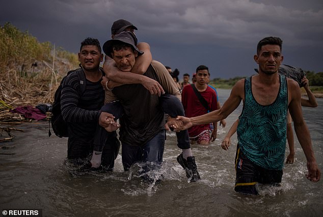 Migrants from Venezuela are seen wading through the Rio Grande to arrive at Eagle Pass on September 15