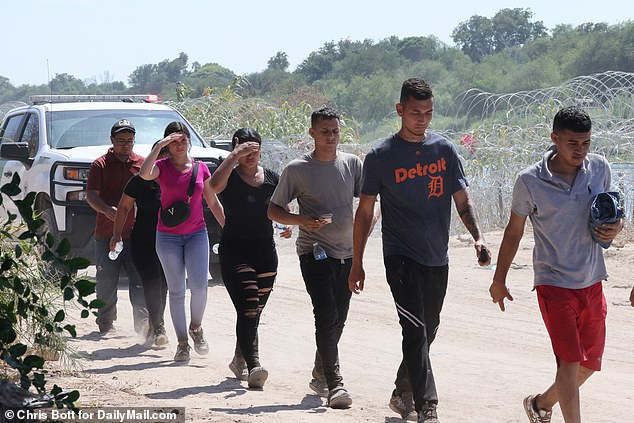 Migrants marched by border patrol to be processed as they entered the US at Eagle Pass on the US-Mexico border, which was much calmer on Friday