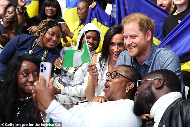 Harry was seen smiling next to Meghan as the pair cheered on competitors and took selfies with adoring fans