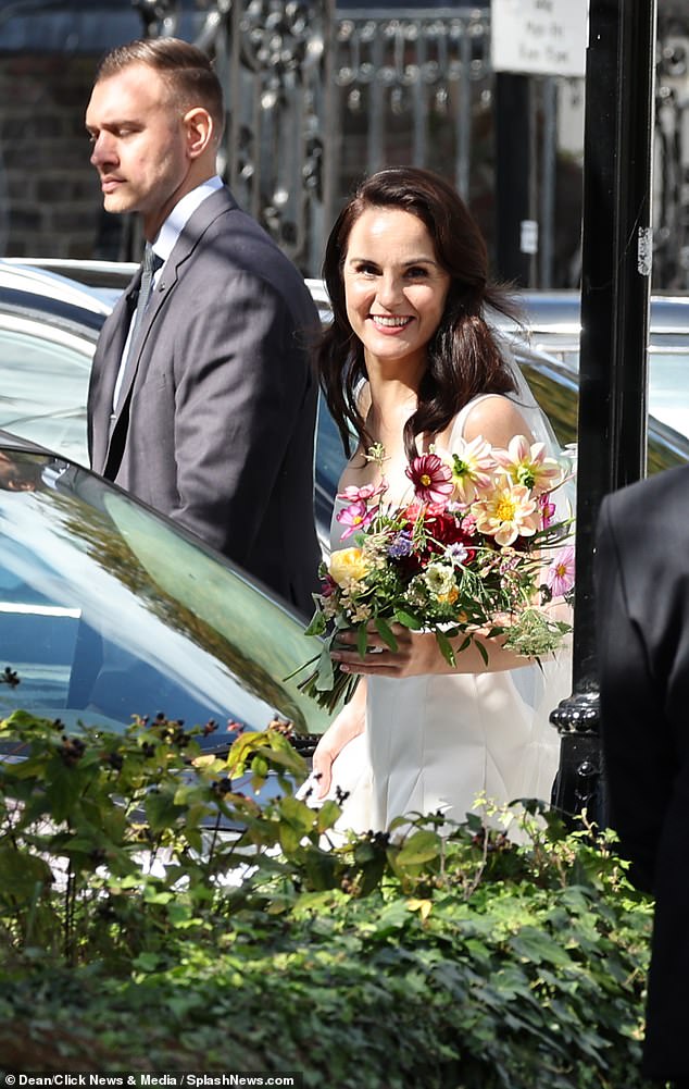 Michelle beamed on the day of her wedding as she held a blooming bouquet