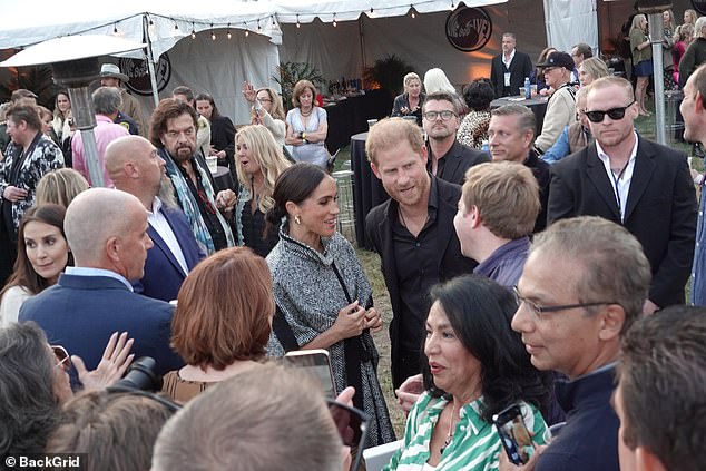 The focus of her outfit was a statement cape-style jacket, with a high funnel neck and tie at the waist, in a black and white striped pattern