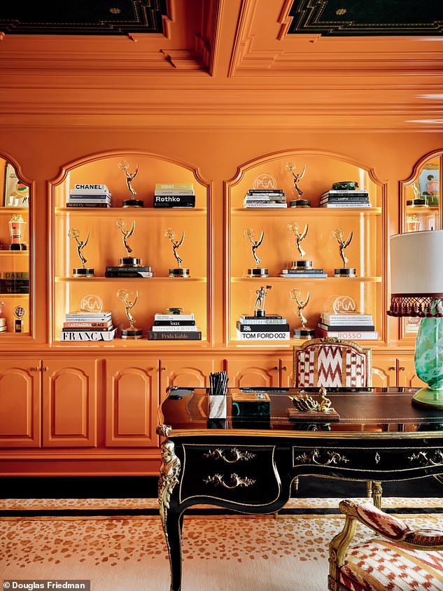 The home office, painted in Hermès orange, contains some of RuPaul's many gongs, including twelve Emmys and multiple MTV awards.  A 19th-century French desk from Ceylon et Cie in Dallas adds an extra touch of glamour