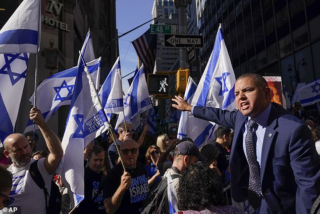 A police officer asks demonstrators gathered outside President Joe Biden's hotel in New York to move as they chant slogans and chant loudly along Lexington Avenue, from where Biden met with Israeli Prime Minister Benjamin Netanyahu