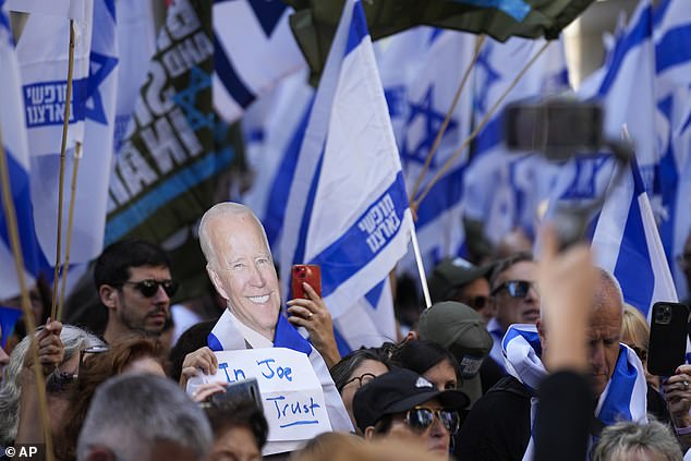 A protester holds up a sign reading 