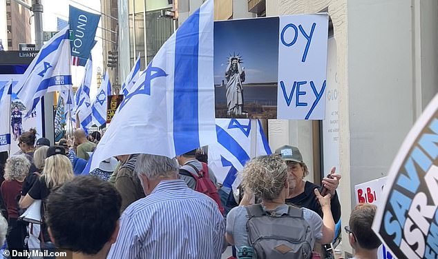 A protester holds up a sign reading 