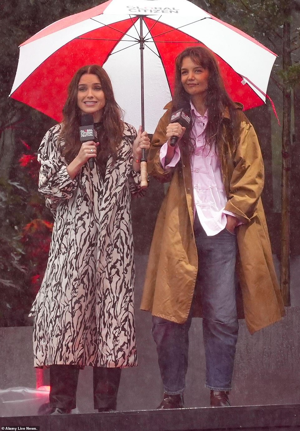 Showers: Sophia Bush and Katie Holmes braved the rain while standing under a large red and white umbrella