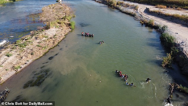 The 100-strong crowd had arrived in Piedras Negras on the Mexican side early Saturday morning and headed for an unshaded island in the middle of the river.