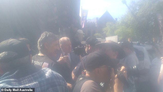 A far-right group tried to take the stage at the No campaign rally in Sydney but were stopped by former UAP MP Craig Kelly (pictured center back).