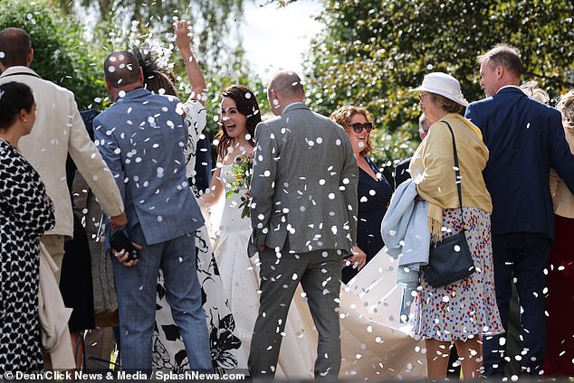 Stunning: Dashing bride Michelle Dockery looked overjoyed as her guests threw confetti today