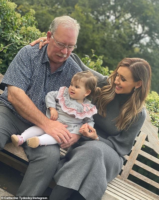 Family: Catherine, wearing a cozy gray knit sweater dress and boots, posted photos with her father and daughter Iris, 16 months