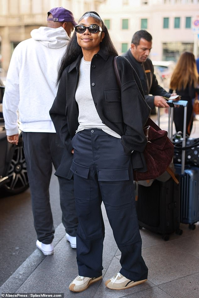 Ready to fly: she had her dark hair half up, half down and wore sunglasses while carrying a large brown bag