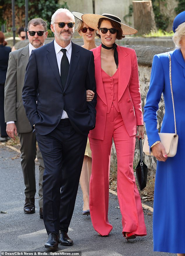 Hard to miss: The star wore a bright pink Etro suit, which cost £1,945, a matching £400 waistcoat and a black tie as she attended the wedding with partner Martin McDonagh this weekend