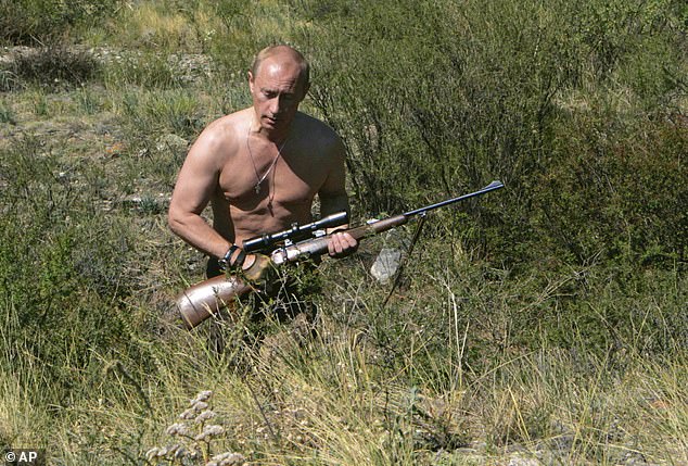 Putin carries a hunting rifle during his trip in Ubsunur Hollow in Siberia's Tyva region, October 30, 2010