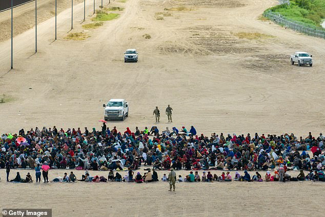 In an aerial view, migrants are seen grouped together as they await processing on the Ciudad Juarez side of the border on September 21, 2023 in El Paso